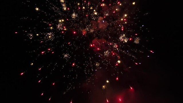 Multiple fireworks exploding at the same time at a fireworks display while I drone captures them.