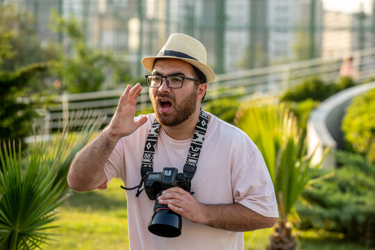 photographer in hat at park with camera professional guy on the photoshoot yelling