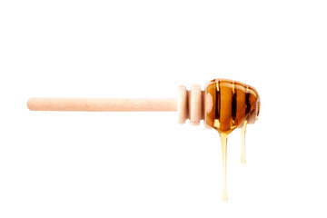 Honey dripping from a wooden dipper on white background