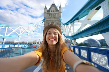 Fotobehang Tower Bridge Smiling girl takes selfie photo on Tower Bridge in London, United Kingdom