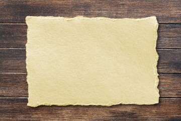 Inspirational handmade paper against rustic weathered wood, storytelling and narration concept.