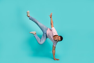 Full length photo of cheerful funny man dressed pink t-shirt dancing standing hands arms isolated turquoise color background