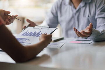 Meeting during discussions on financial analysis and marketing document. Business people talking about business strategy and chart graph showing the growth of investment result of successful teamwork.