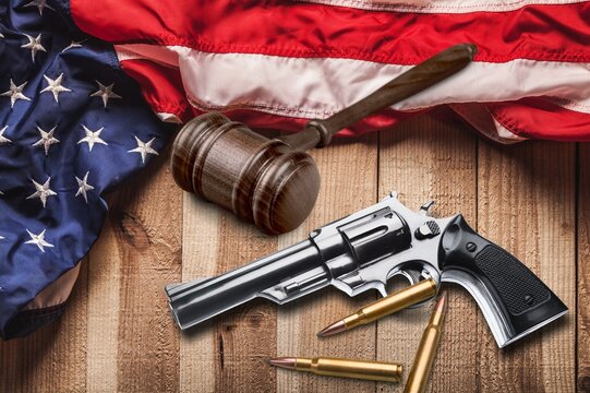 Wooden Gavel with gun over USA flag.