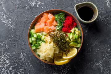Poke with salmon, chukka,avocado,cucumber,ginger,nori and lemon top view on grey table