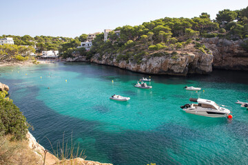 Fototapeta na wymiar Mallorca, Spain - Boats in a cove in the mediterranean sea blue green color