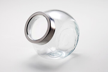 Empty round glass jar with silver lid, isolated on white