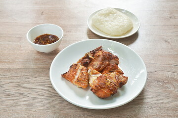grilled slice chicken wing on plate dipping with spicy sauce 