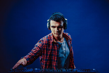 exicted dj sound device oprator with headphones by dancing at club - concept of entertainment,...