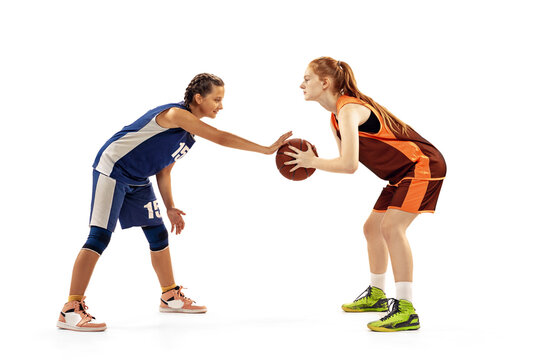 Two basketball players, young girls, teen playing basketball isolated on white background. Concept of sport, team, enegry, competition, skills