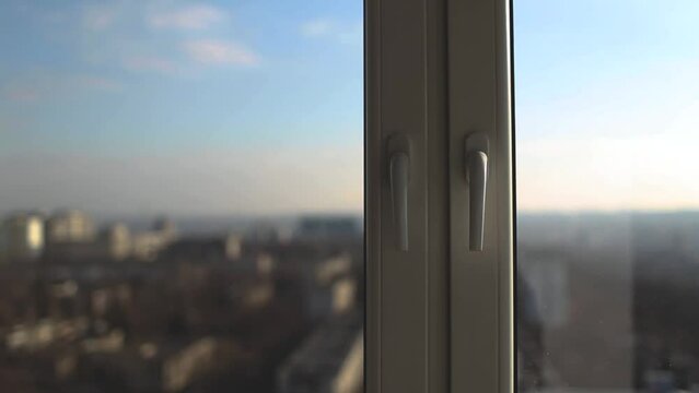 Close-up of handle of plastic windows in sunny day on background of blue sky.