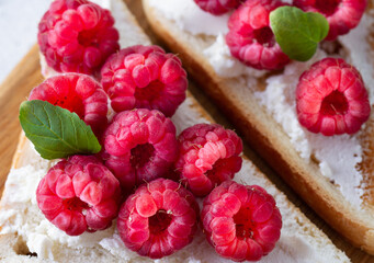 Sandwich with cream cheese and raspberries close-up