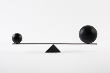 Black balls balancing on scales