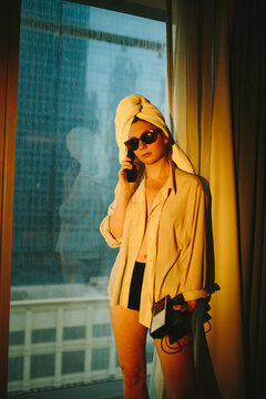 Young lady having phone conversation in hotel room