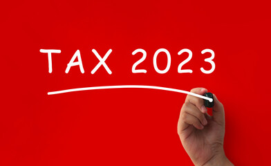 Tax 2023 written on red cover background. Tax concept