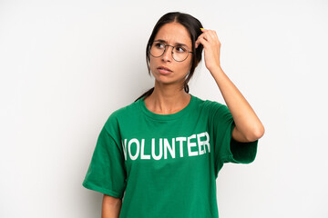 hispanic pretty woman smiling happily and daydreaming or doubting. volunteer concept