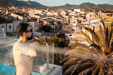Bearded man standing on rooftop and admiring townscape