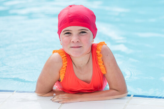 Serious Kid Swimming In Pool And Looking At Camera