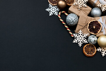 Naklejka premium Beautiful Christmas golden silver decorations on a dark black background. Flat design, postcard, calendar, banner. Place for text.