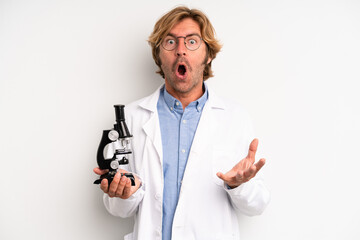 blond adult man amazed, shocked and astonished with an unbelievable surprise. scientist with a...