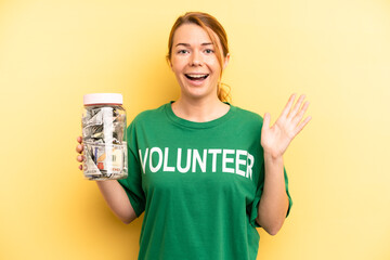 pretty blonde young woman feeling happy and astonished at something unbelievable. donation and...