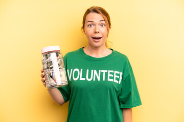 pretty blonde young woman looking happy and pleasantly surprised. donation and volunteer concept