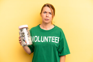 pretty blonde young woman feeling puzzled and confused. donation and volunteer concept
