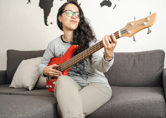 Latin girl enjoying her practice with the bass at home.