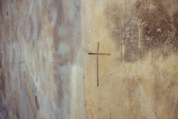Cross drawn on shabby wall