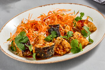 Traditional chinese dish - crispy eggplant with sweet chili sauce. Vegan food - stir fried eggplant with vegetables. Crispy aubergine with chilli sauce on ceramic plate. Modern asian food.