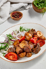 Traditional georgian dish odjahuri with meat and potatoes. Roasted pork fillet and potatoes with onion and tomatoes. Stew meat and potatoes. Eastern food with pork and spices
