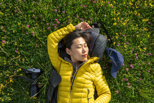 Portrait of beautiful Asian girl lying down on the grass holding