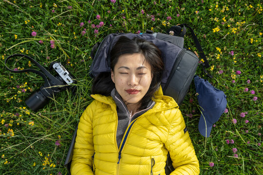Portrait of beautiful Asian girl lying down on the grass holding