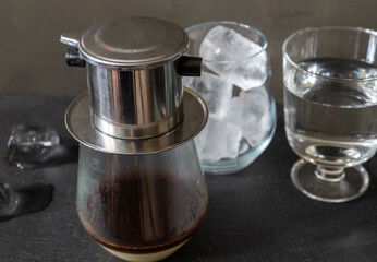 A traditional Vietnamese way of brewing coffee using a special filter - phin. Coffee with condensed milk and ice.