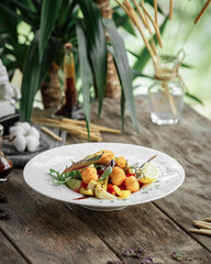 Gourmet dish with artichokes and deep fried cheese on wooden background