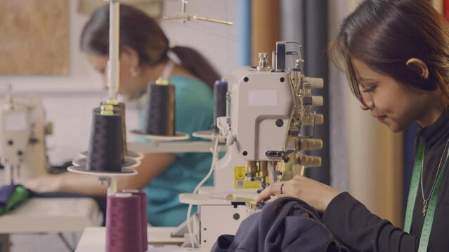 Latin women use a sewing machine in their craft workshop.