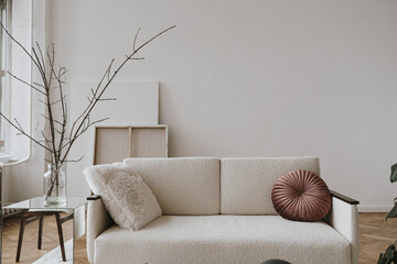 Elegant Scandinavian hygge style home living room interior. Cozy comfortable sofa, pillows, white walls. Aesthetic luxury bright apartment interior design concept