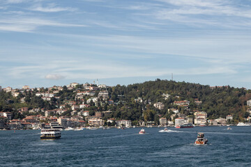 Fototapeta na wymiar View of yachts and cruise tour boats on Bosphorus and Bebek neighborhood on European side of Istanbul. It is a sunny summer day. Beautiful travel scene.