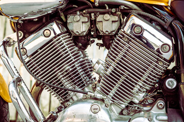 Motorcycle engine detail. Shiny, custom, chrome, stylish, yellow motorbike motor fragment close up....