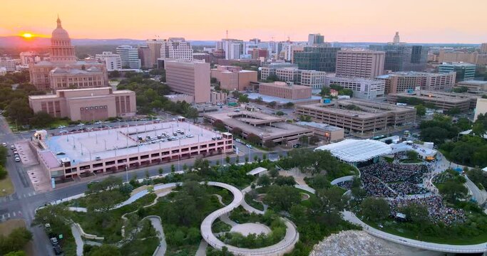 Pulling away from sunset in Austin, Texas, with view of Capital building and Waterloo Park. Bird's eye view of the surrounding apartment buildings.