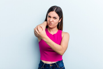 Young caucasian woman isolated on blue background having a neck pain due to stress, massaging and touching it with hand.