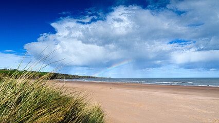 Fototapeta na wymiar Rainbow over Lunanbay beach Angus Scotland