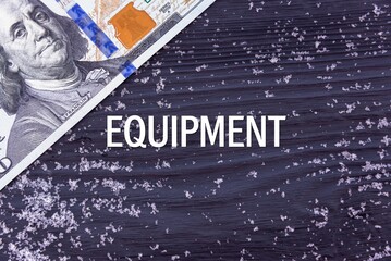 EQUIPMENT - word (text) on a dark wooden background, money, dollars and snow. Business concept (copy space).