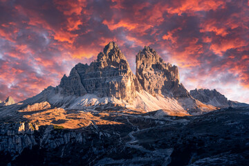 Dramatic evening landscape with Three peaks of Lavaredo mountains, glowing road and pink sunset sky. Auronzo refugio at Tre Cime Di Lavaredo National Park, Dolomite Alps, Trentino Alto adige, Italy