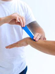 Obraz premium Physiotherapy treatment with therapeutic kinesiology tape for wrist pain, aches and tension. Prevention and treatment in competitive sports. Hand with kinesiology tape.