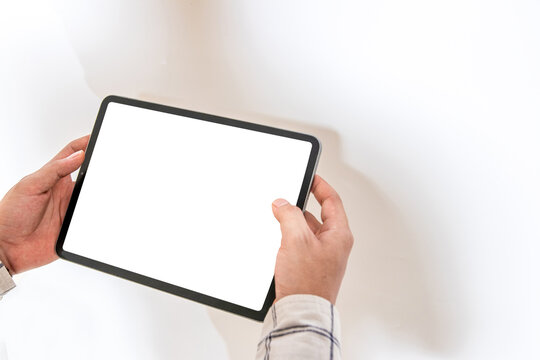 Mockup image of a man holding a white blank screen tablet