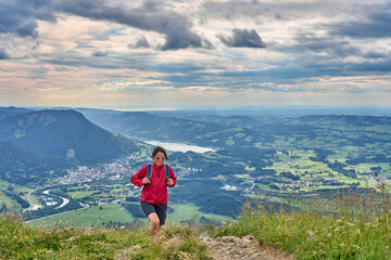nice senior woman hiking at Mount Gruenten in the Allgaeu Alps with awesomw view over Iller valley...
