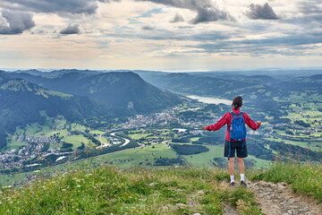 Naklejka premium nice senior woman hiking at Mount Gruenten in the Allgaeu Alps with awesomw view over Iller valley to Lake Alpsee and Lake of Constanz, Bodensee, Bavaria, Germany