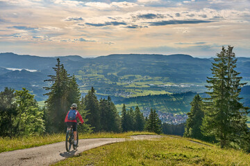 Fototapeta na wymiar nice active senior woman riding her electric mountain bike at Mount Gruenten in the Allgaeu Alps , Bavaria, Germany
