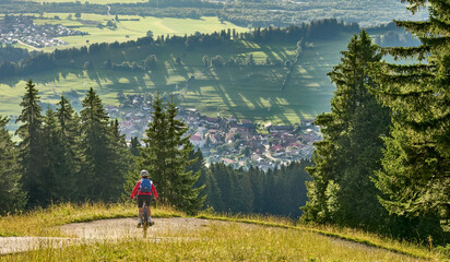 Fototapeta na wymiar nice active senior woman riding her electric mountain bike at Mount Gruenten in the Allgaeu Alps , Bavaria, Germany